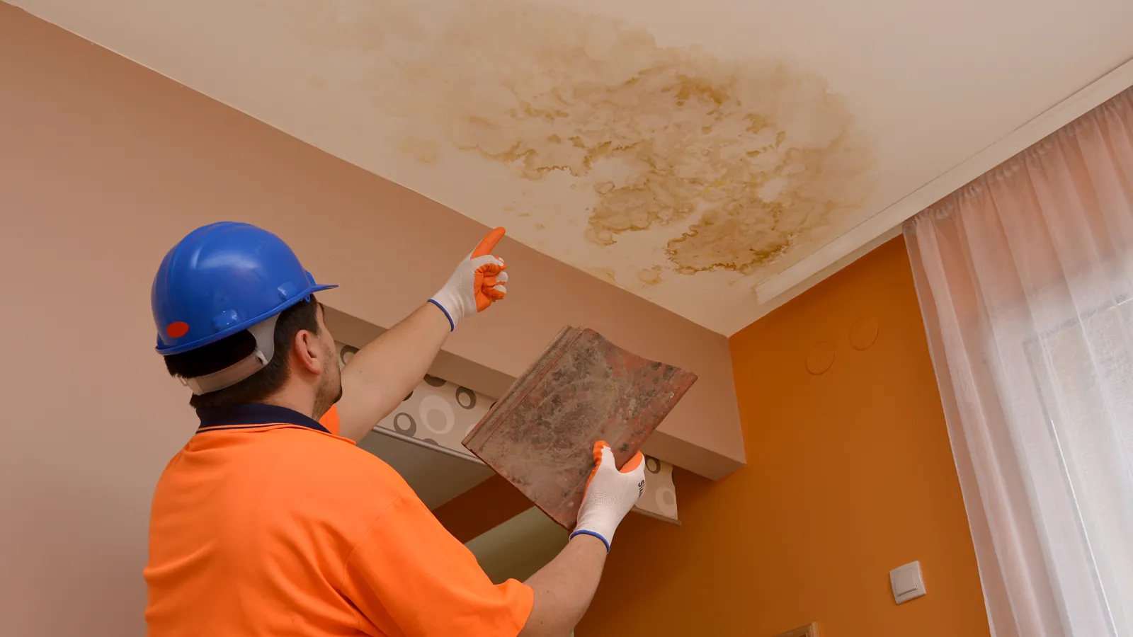 An employee inspecting a damaged roof