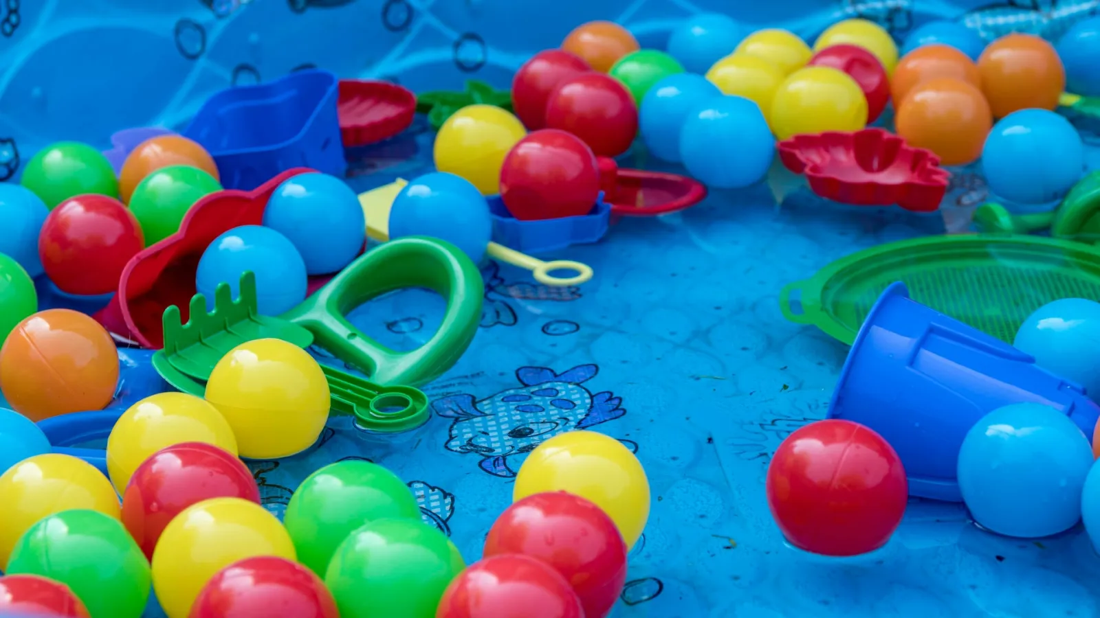 a group of colorful balls floating in a kiddie pool