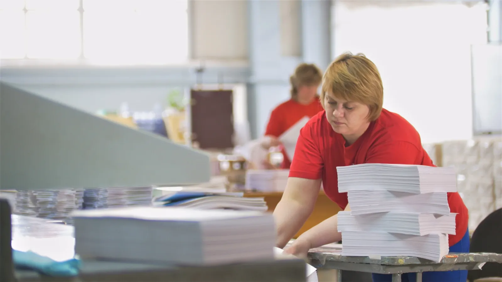 Two women assembling Print Materials