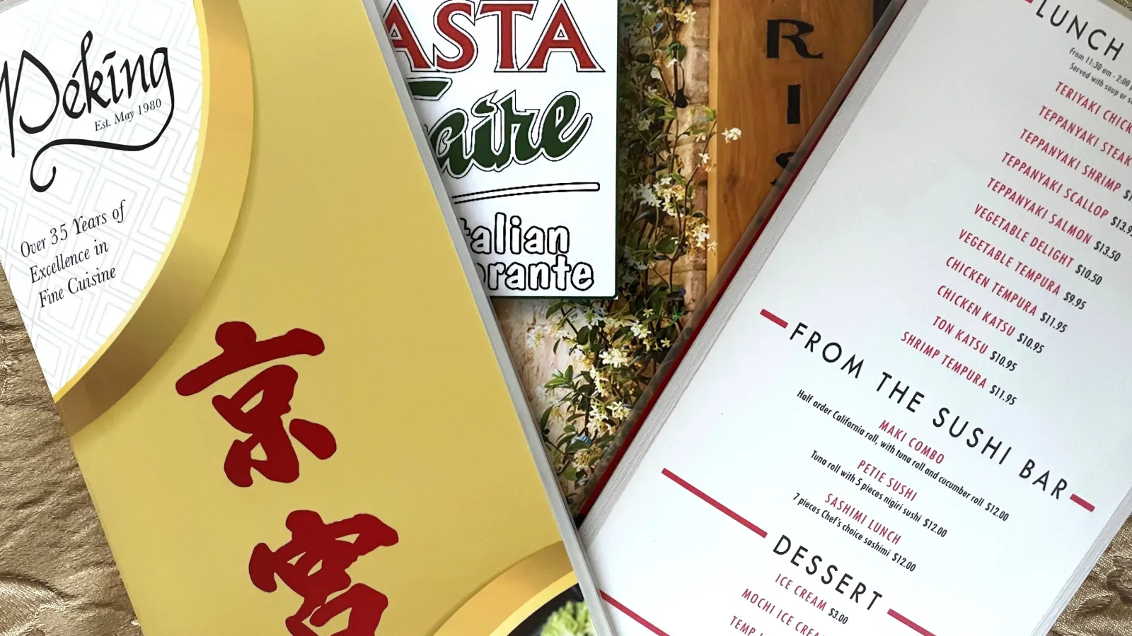 Three different Laminated Menus lying on a gold tablecloth