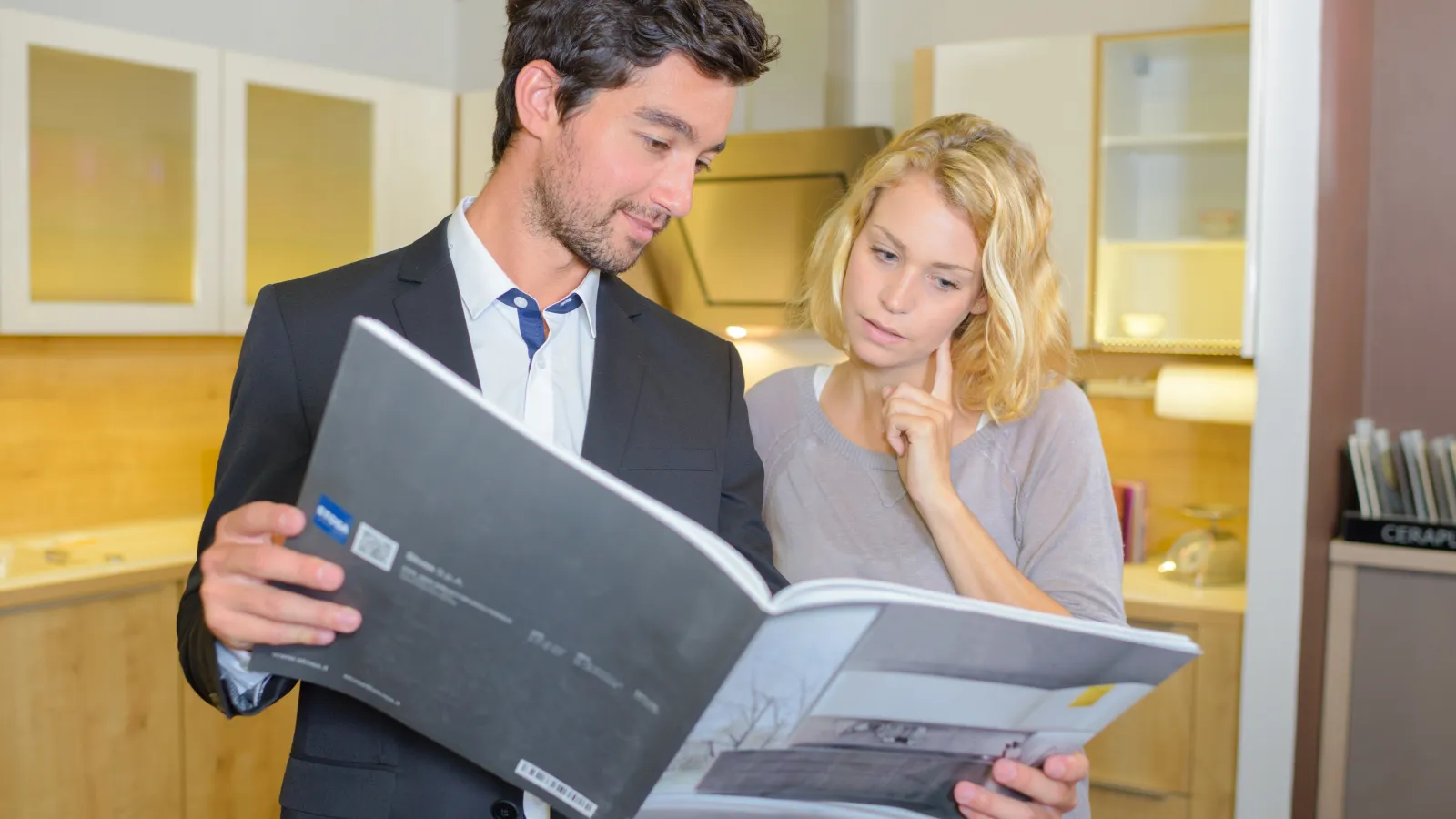 A man and a woman looking through a printed Catalog