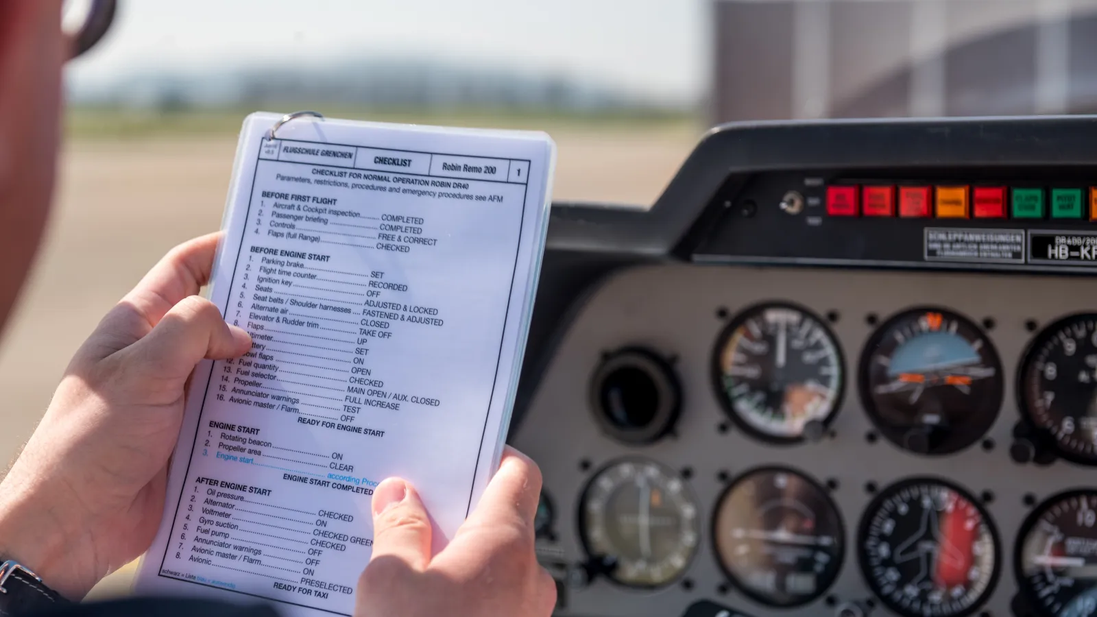 A pilot holding a set of Laminated Reference Cards in the cockpit