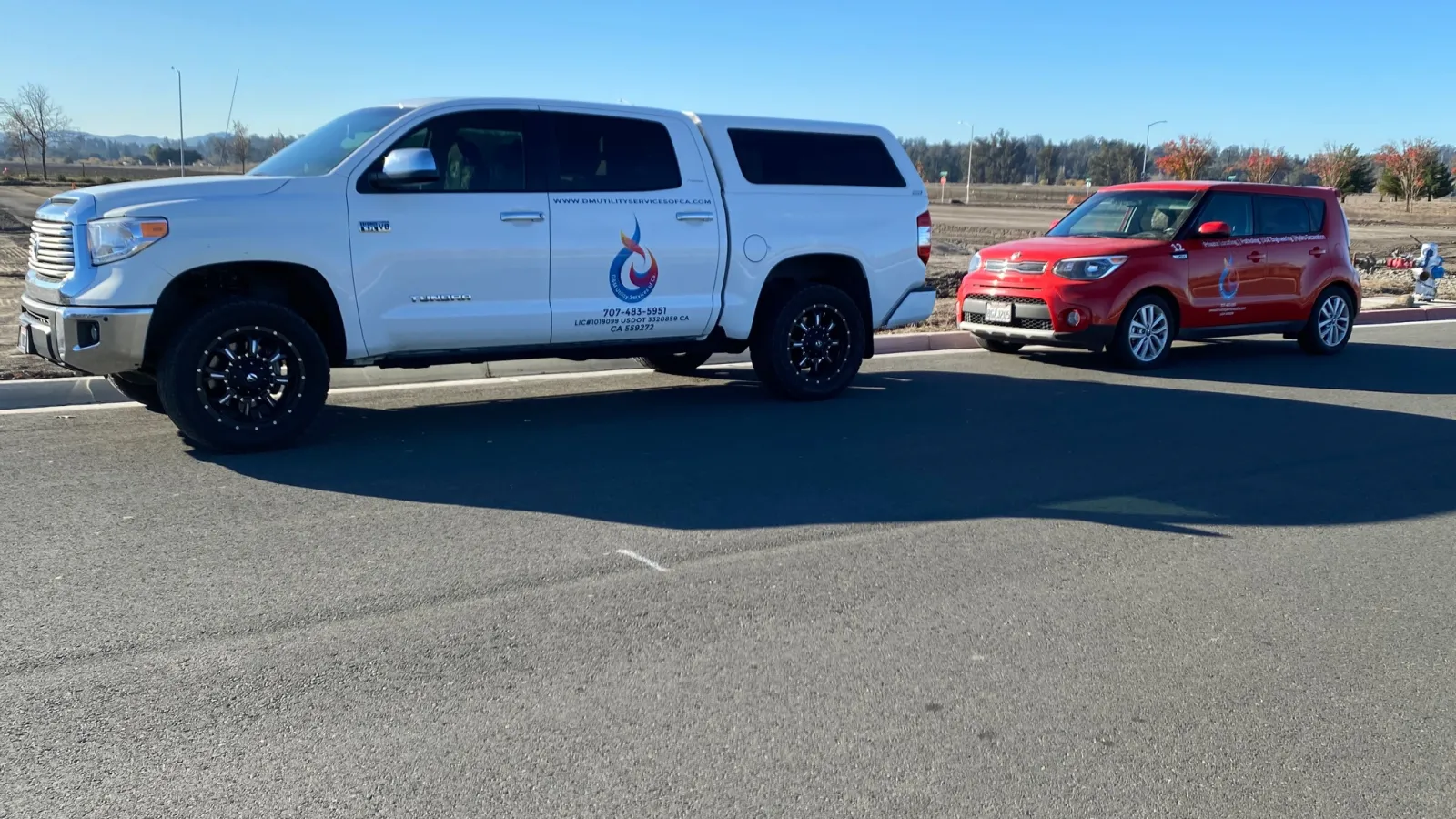 a white truck parked next to a red car