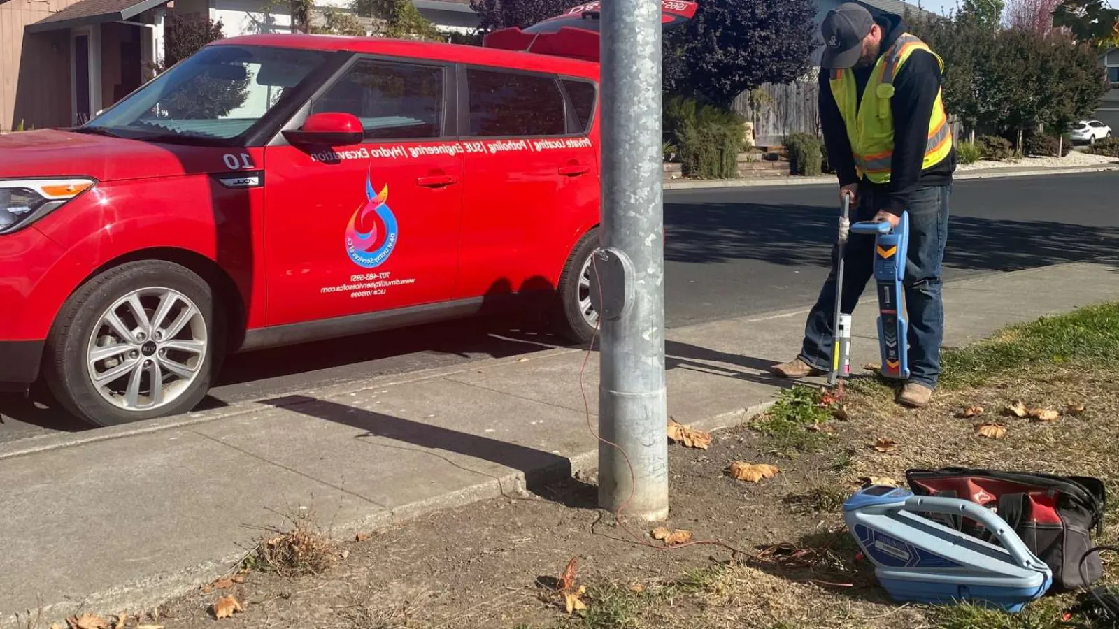 a man doing utility work by a sidewalk