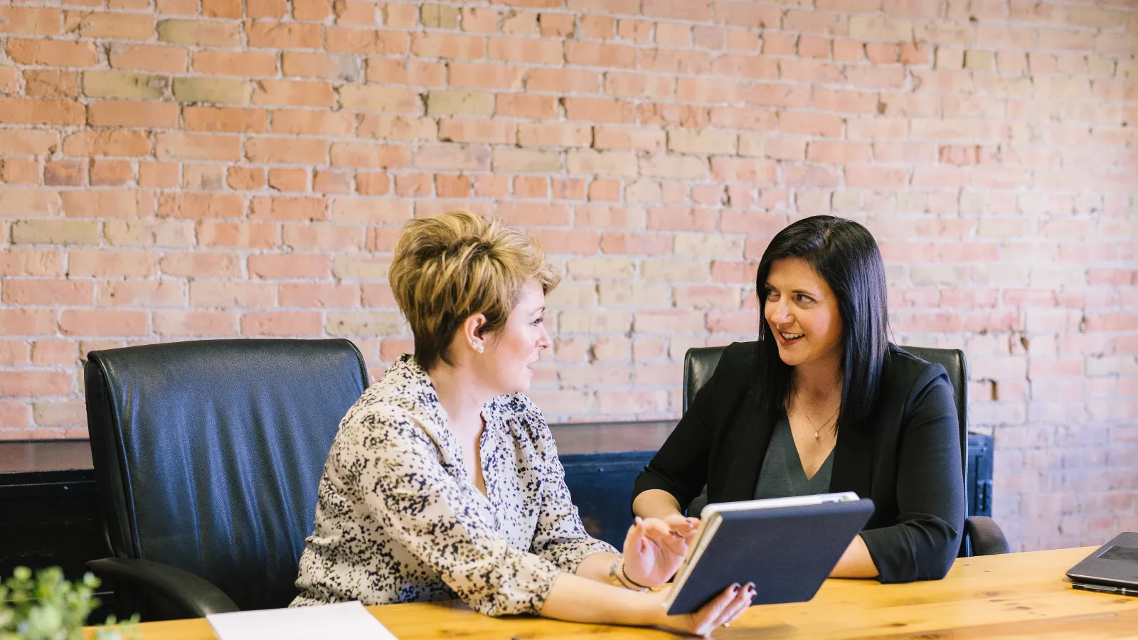 a few women sitting at a table discussing certified payroll options