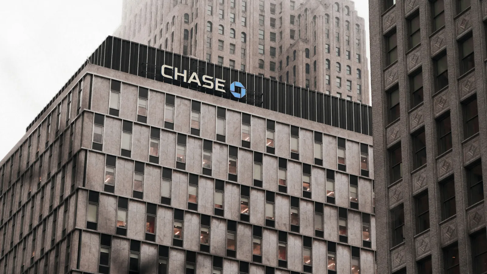 Chase bank building with logo on a cloudy day surrounded by tall office buildings in the city.