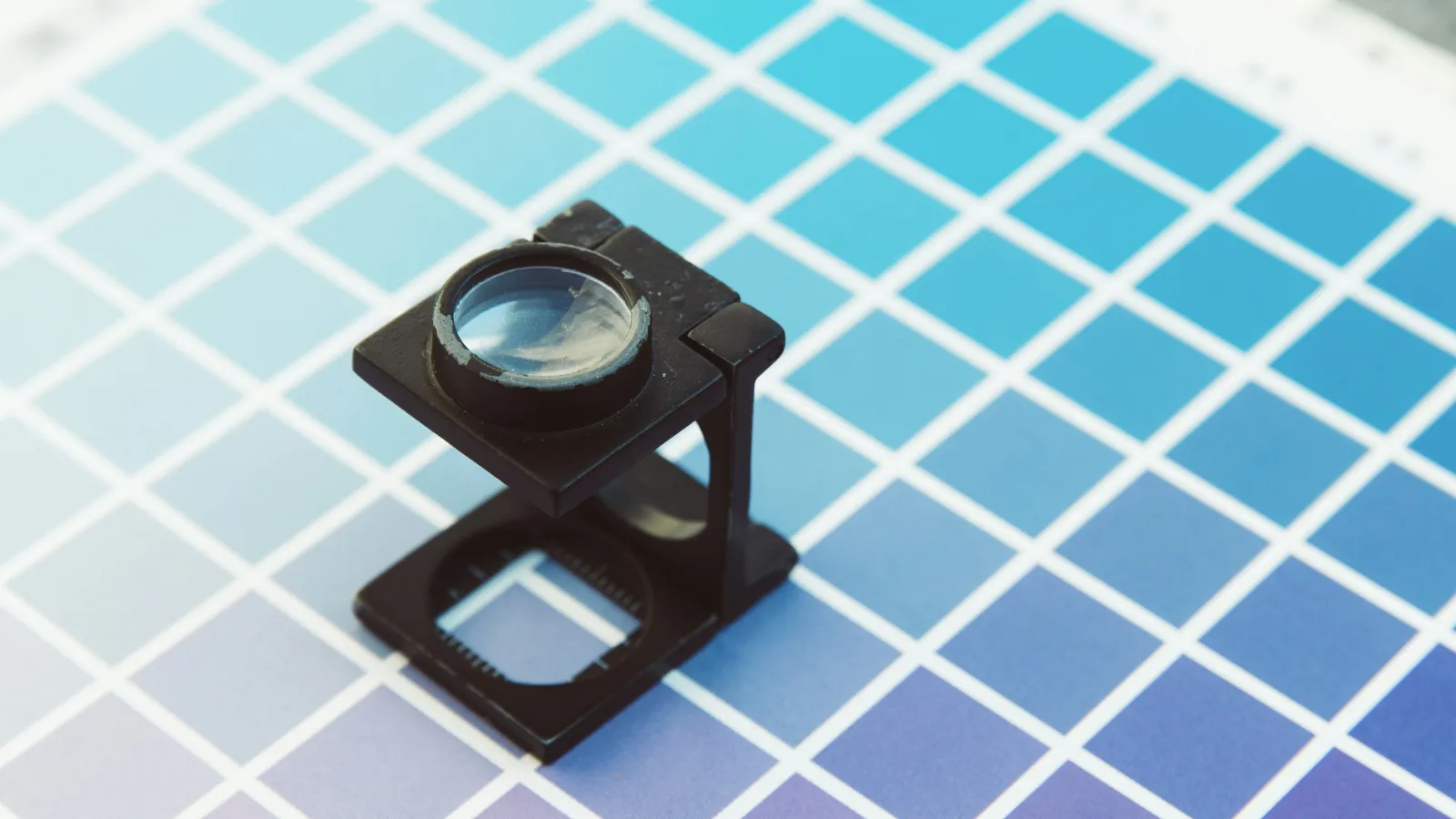 Color swatch sheet with a black magnifying loupe on top, displaying blue to purple gradient shades.