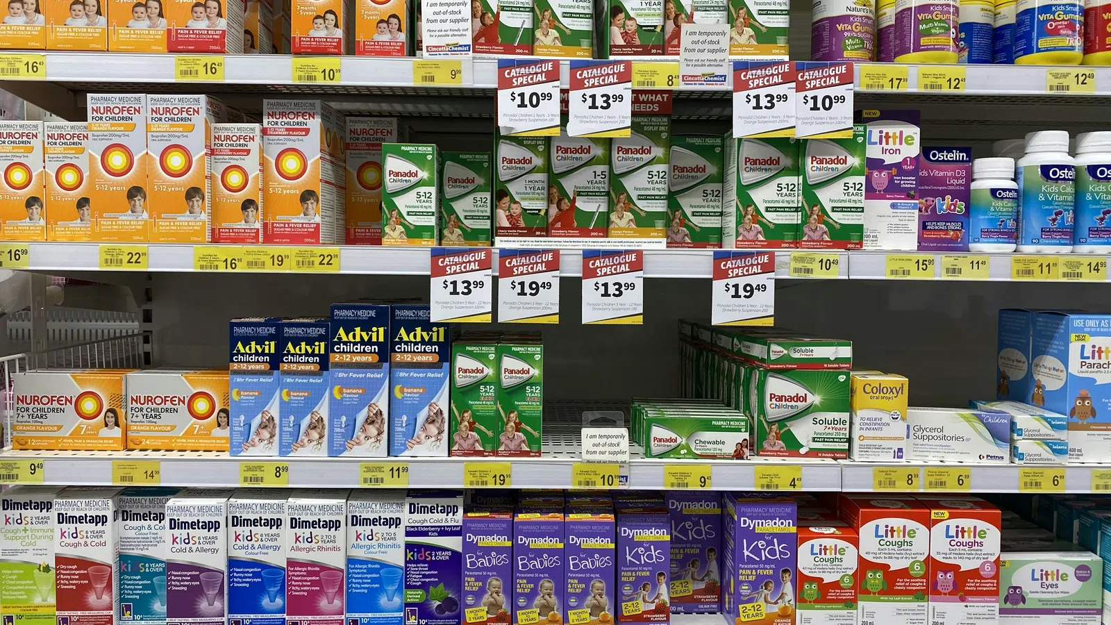 Shelves stocked with children’s medicines including Nurofen, Panadol, Advil, and vitamins in a pharmacy aisle.