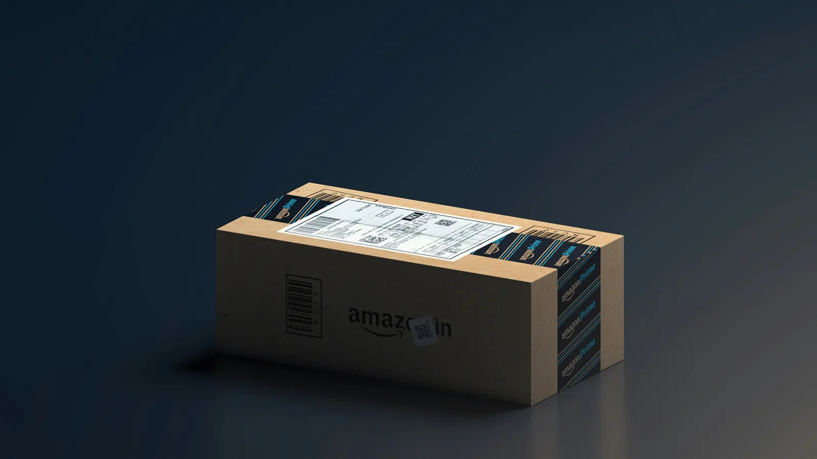 Amazon India delivery package box sealed with branded tape on a dark reflective surface.