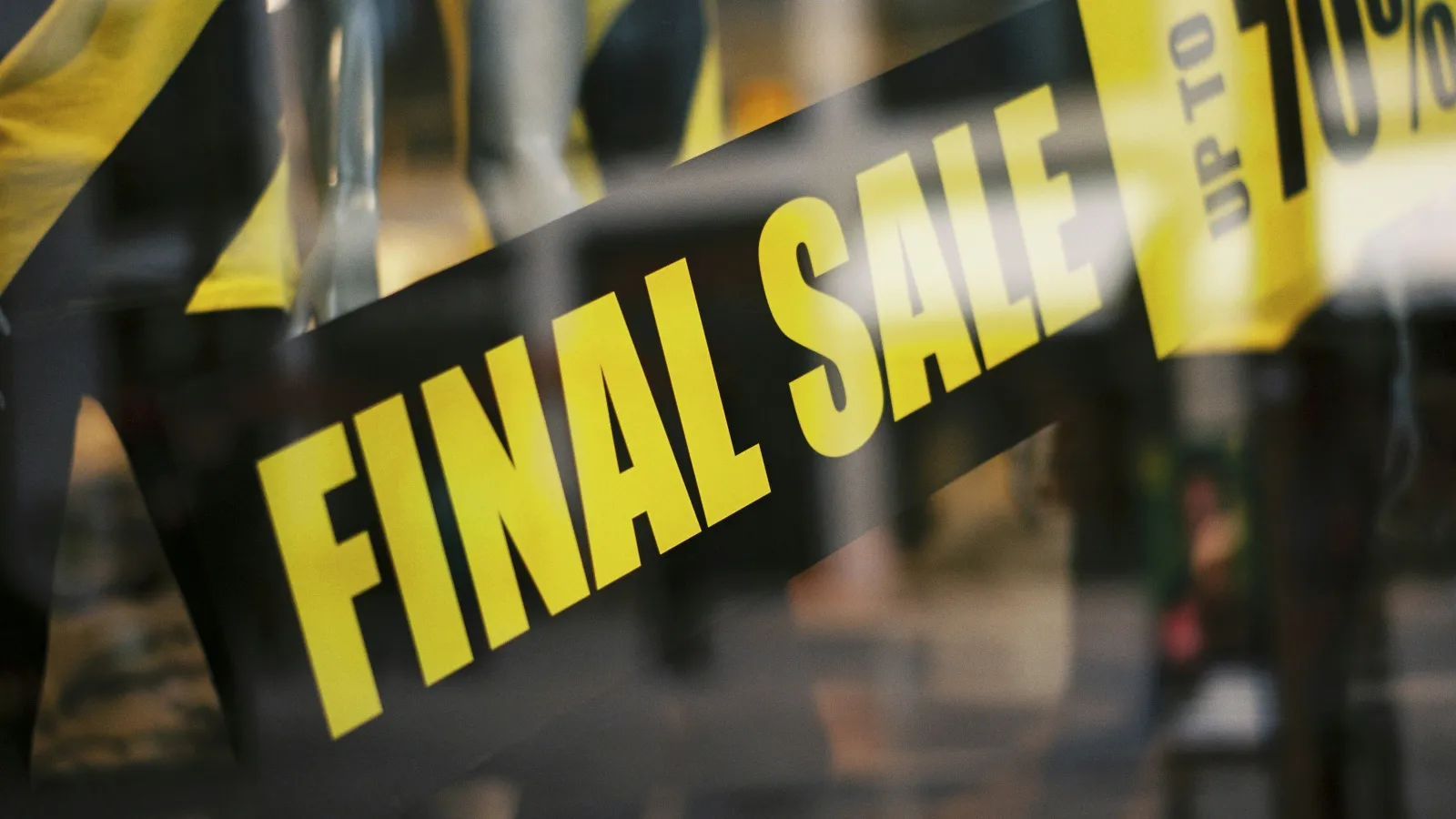 Store window with bold yellow FINAL SALE sign offering discounts up to 70 percent off