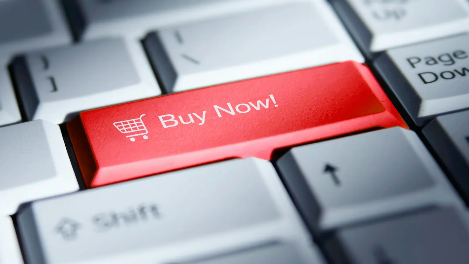 Close-up of a keyboard with a prominent red 'Buy Now!' key featuring a shopping cart icon.