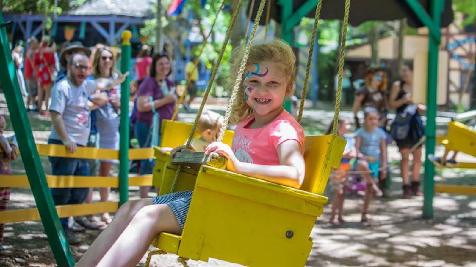 a girl on a yellow and blue playground toy
