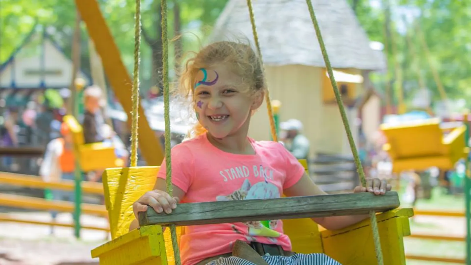 a girl on a yellow playground toy