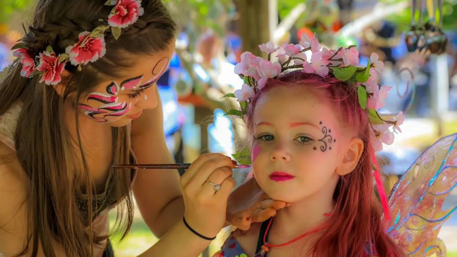 a woman painting a girl's face