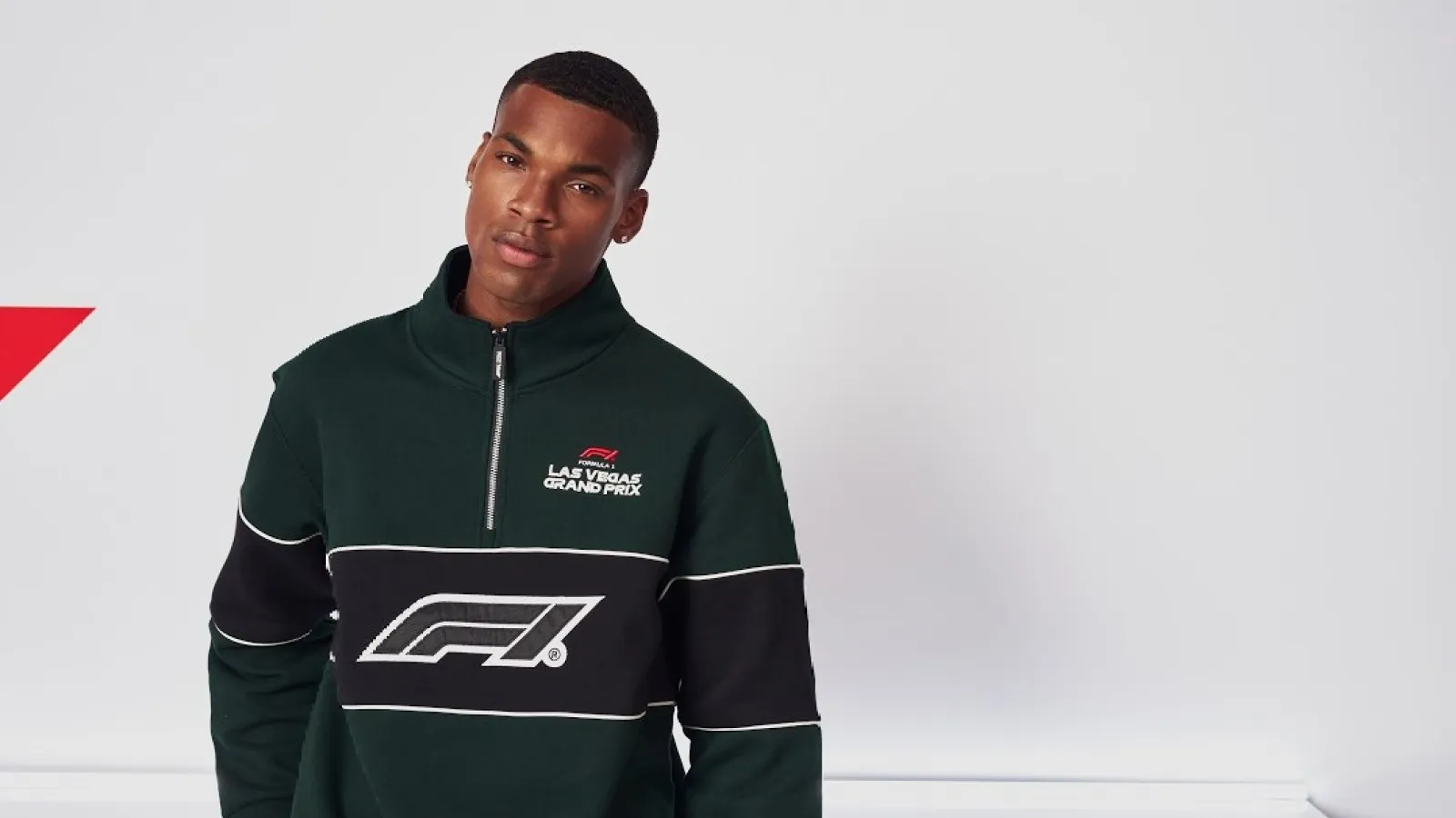 Man wearing dark green and black F1 Las Vegas Grand Prix sweatshirt with half-zip collar against white background