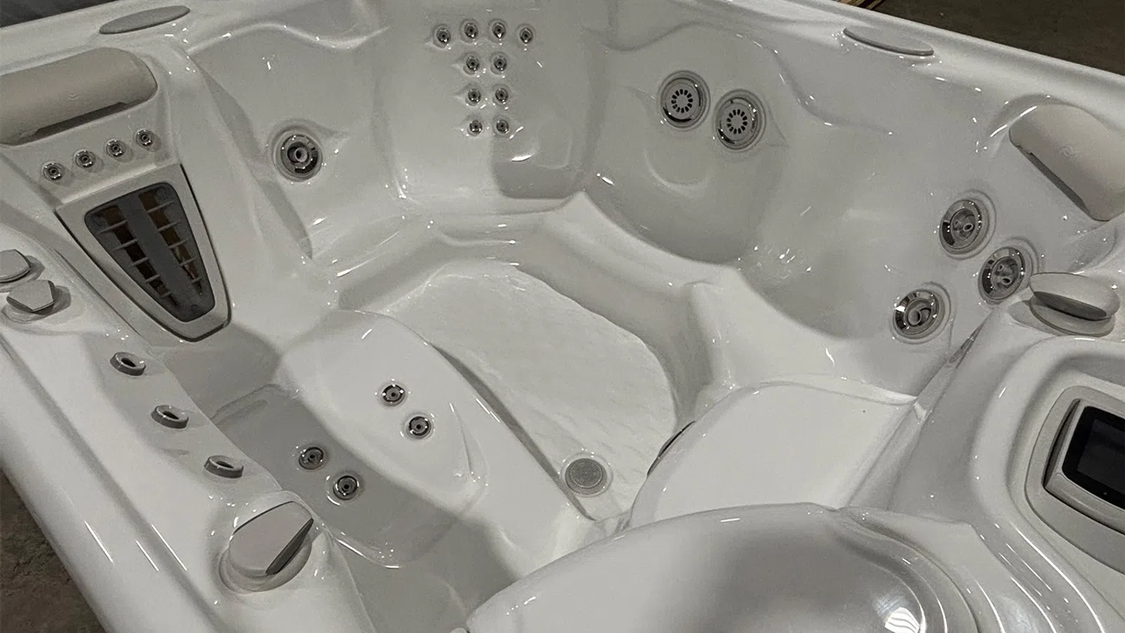 White spa bathtub with multiple jet nozzles and ergonomic seating for hydrotherapy and relaxation.
