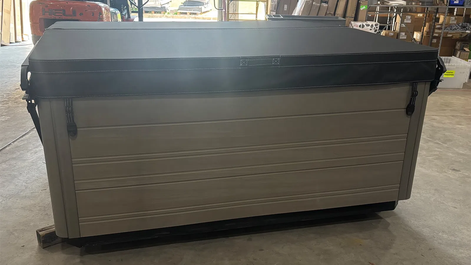 Large beige and black storage container placed indoors on concrete floor in a warehouse setting.