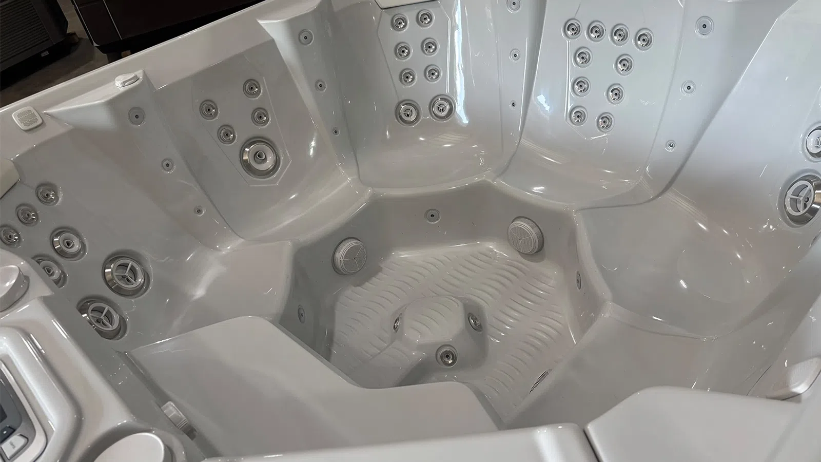 White luxury hot tub with multiple jet nozzles and contoured seating for relaxation and hydrotherapy.