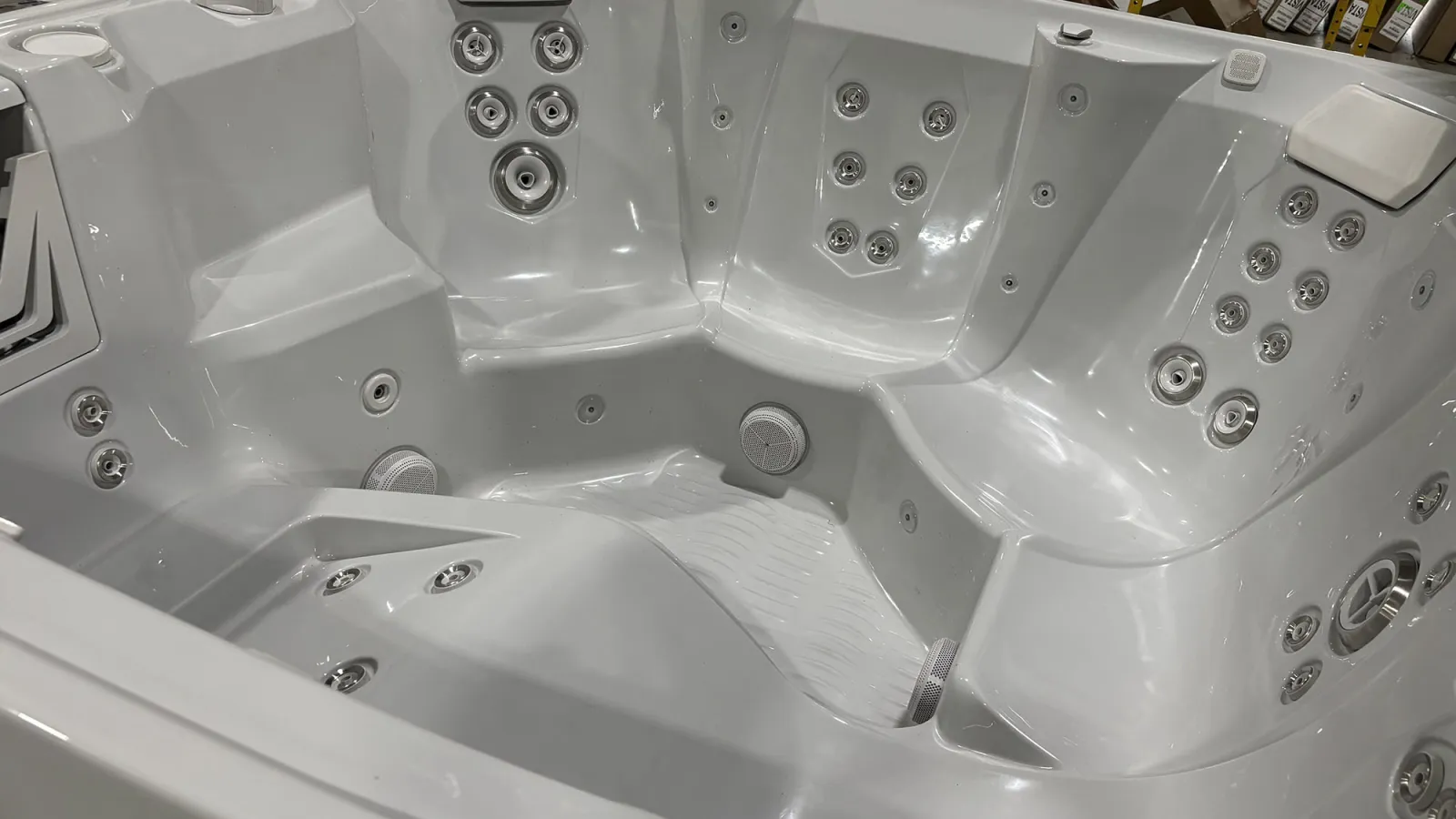 White spacious hot tub with multiple built-in water jets and ergonomic seating for relaxation.