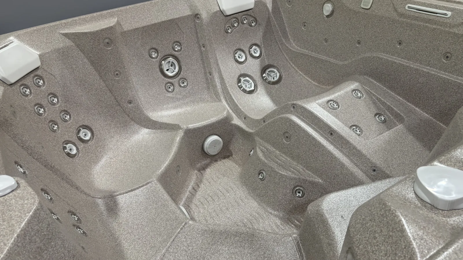 Empty modern hot tub with multiple massage jets and ergonomic seats in metallic gray finish