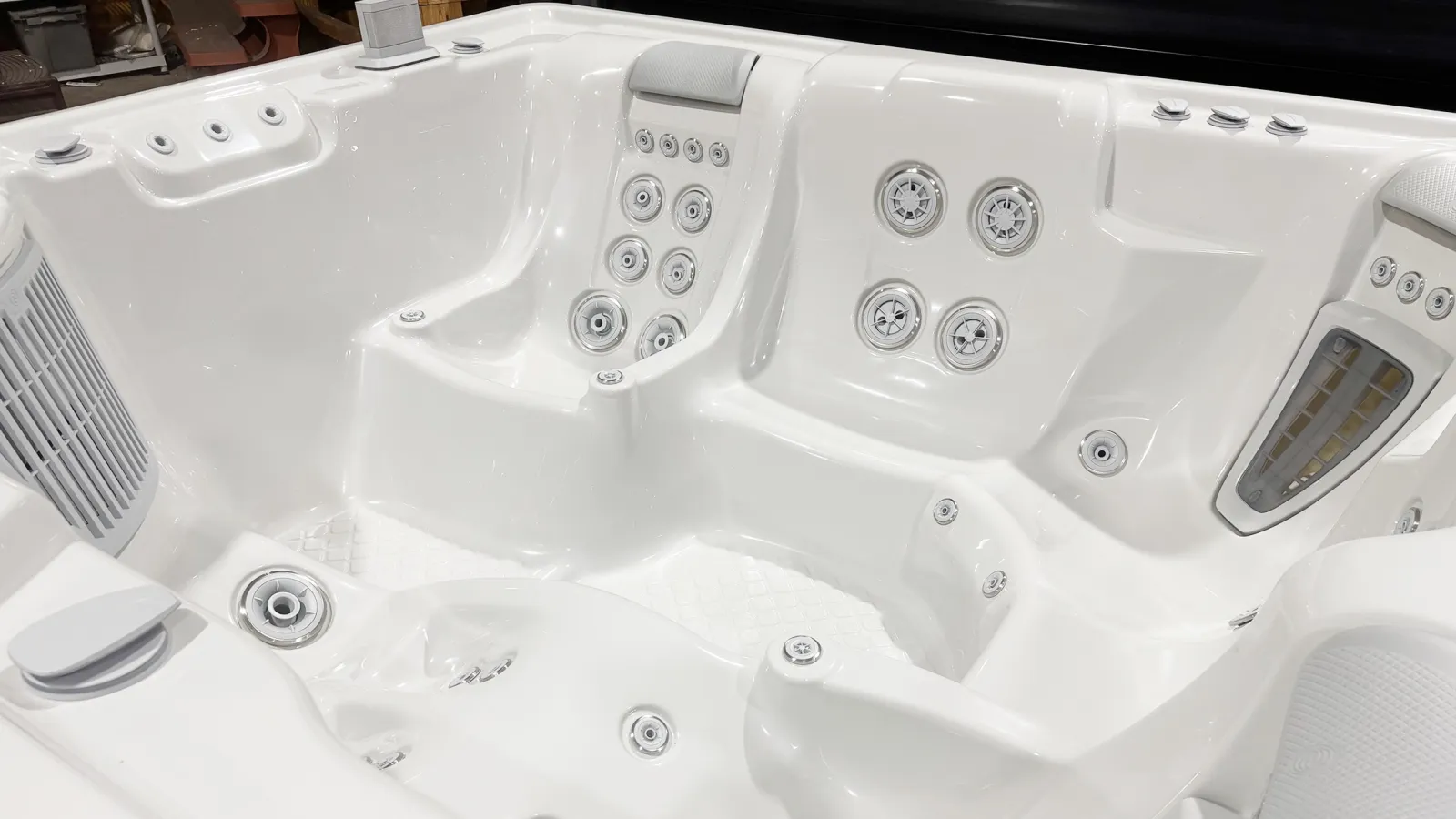 Close-up of a white luxury hot tub interior with multiple water jets and ergonomic seating.
