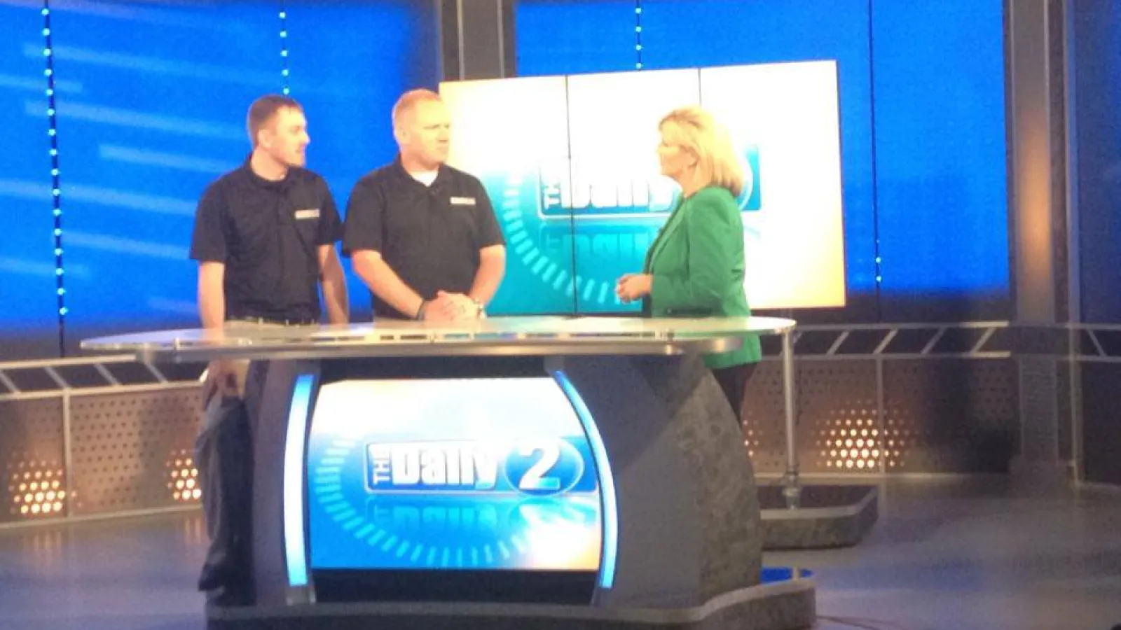 a group of people standing behind a television