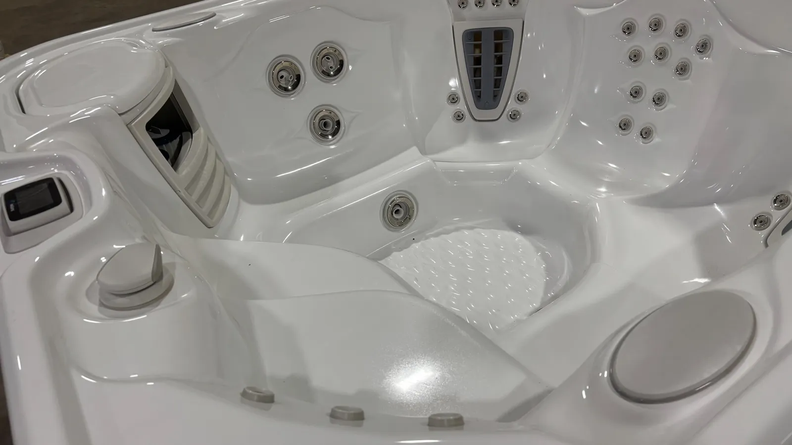 Close-up of a white spa hot tub interior showing multiple water jets and ergonomic seating areas.
