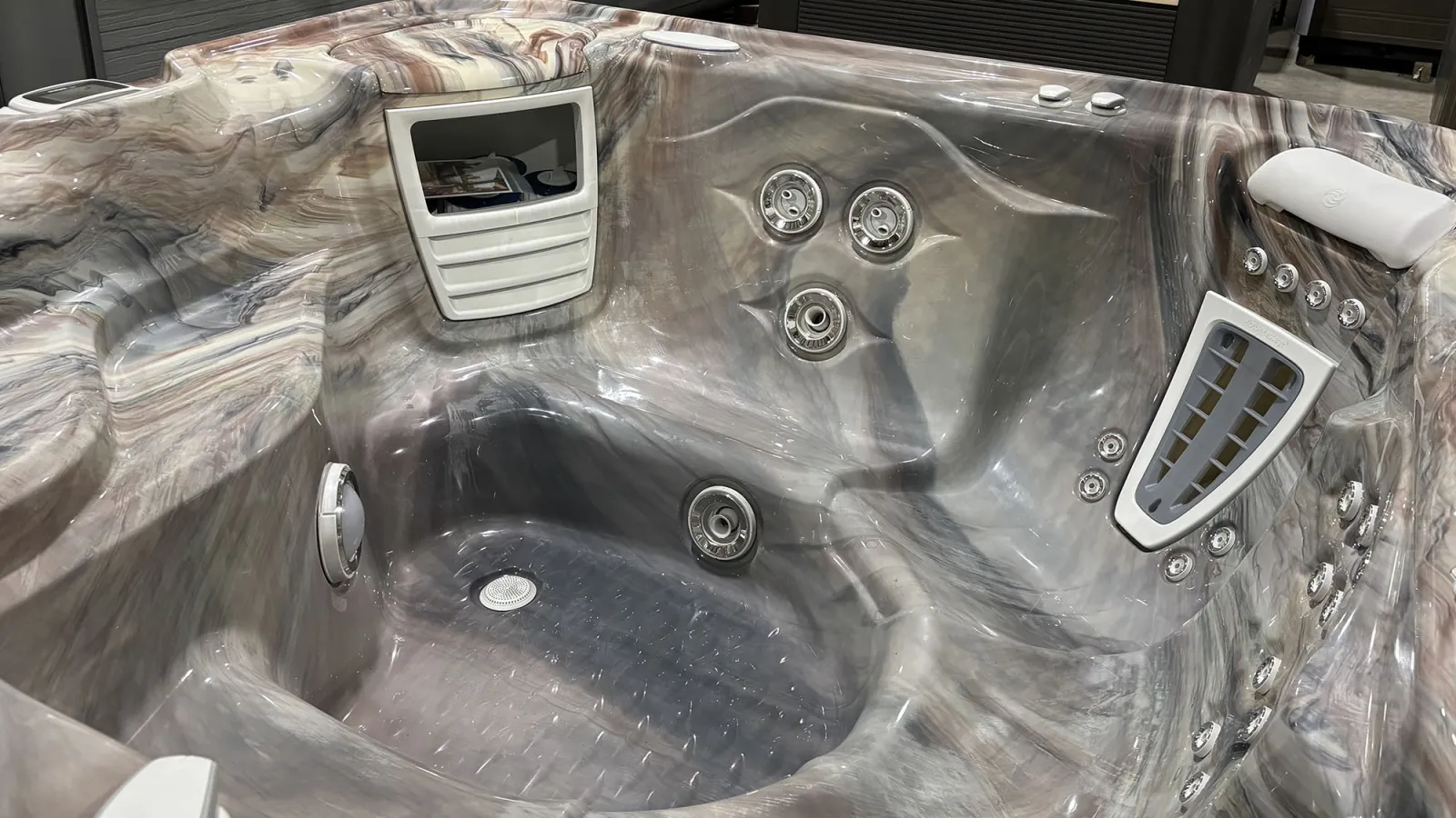 Modern marble-patterned hot tub interior with multiple water jets and ergonomic seating for comfort and relaxation.