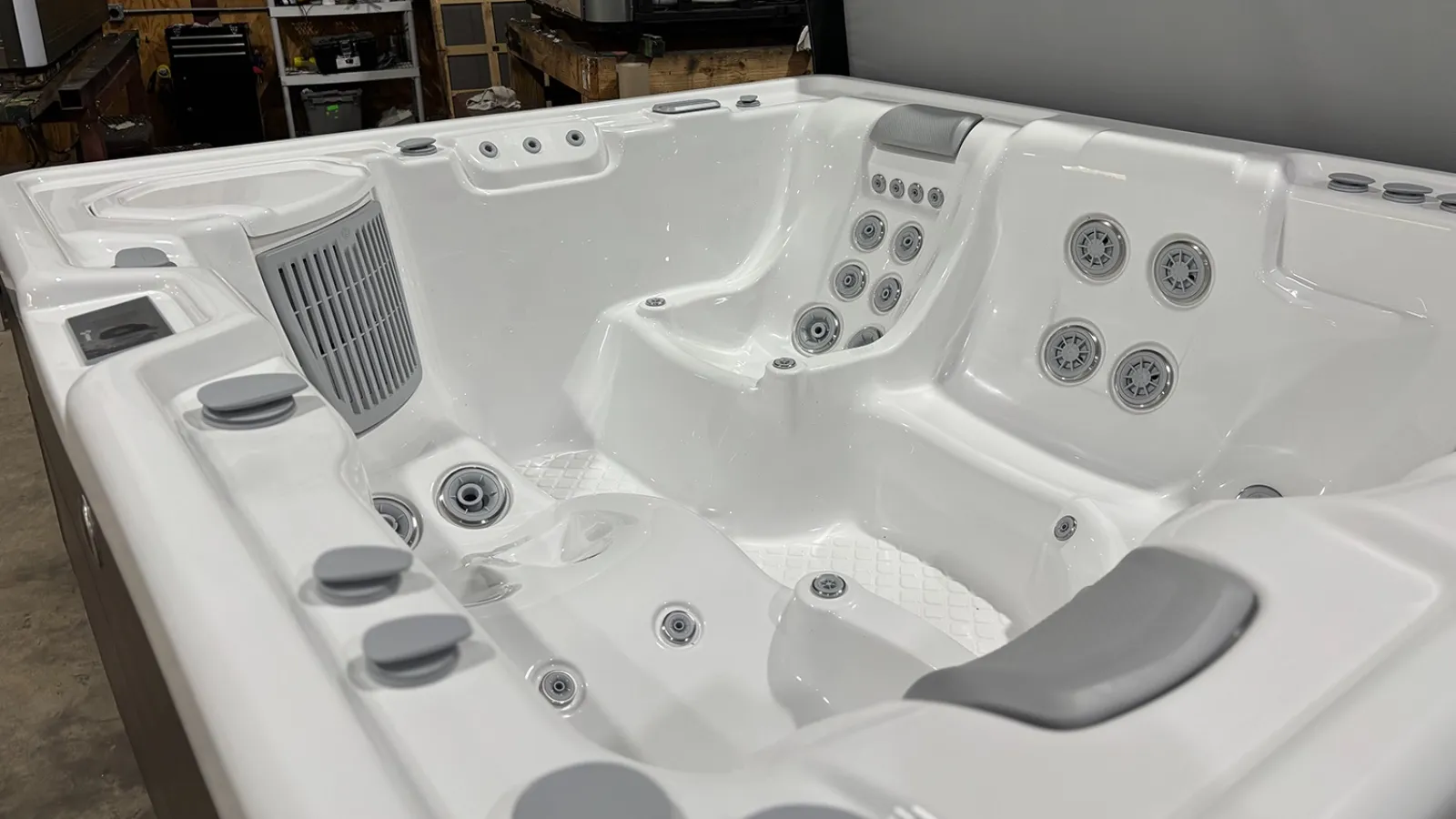 White luxury hot tub with multiple jets and ergonomic seating designed for comfort and relaxation indoors.