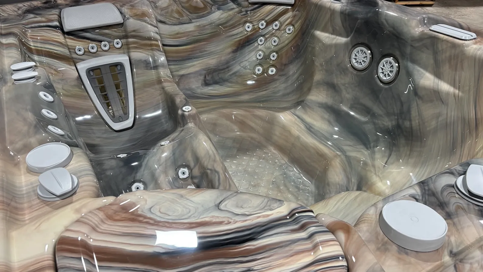 Marble-patterned hot tub with multiple jets, cushioned headrests, and ergonomic seating designed for comfort and relaxation.