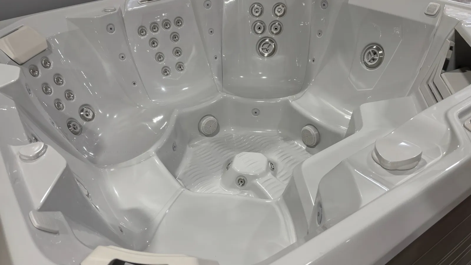 Close-up of a white luxury hot tub with multiple seats and adjustable water jets for relaxation.