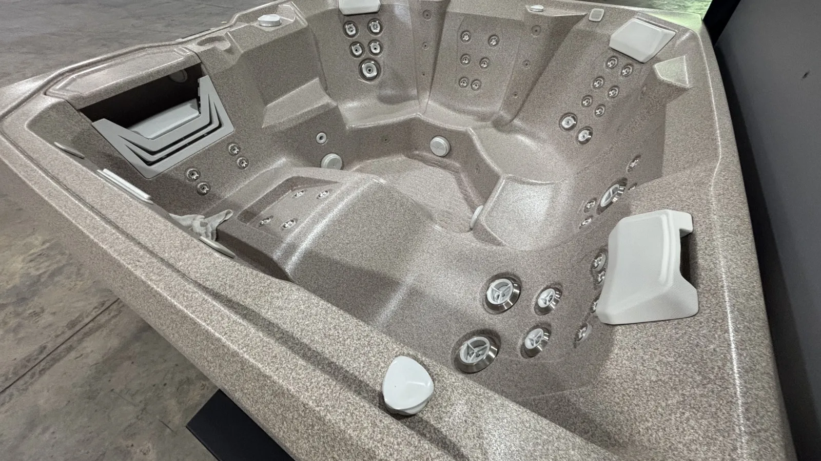 Modern beige hot tub with multiple jet nozzles and ergonomic seating designed for relaxation.