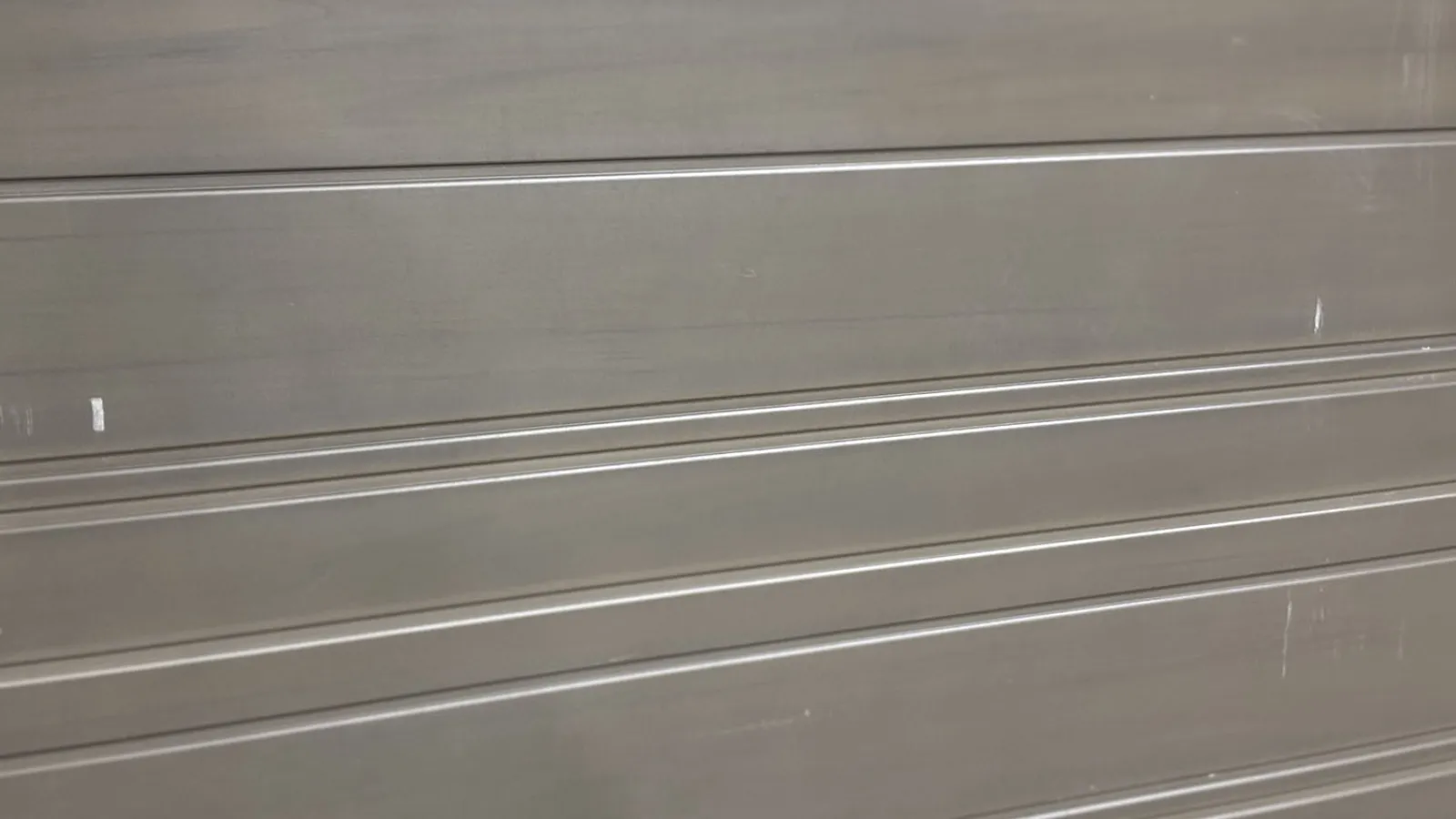 Close-up of a metallic gray garage door with horizontal panels and subtle reflections