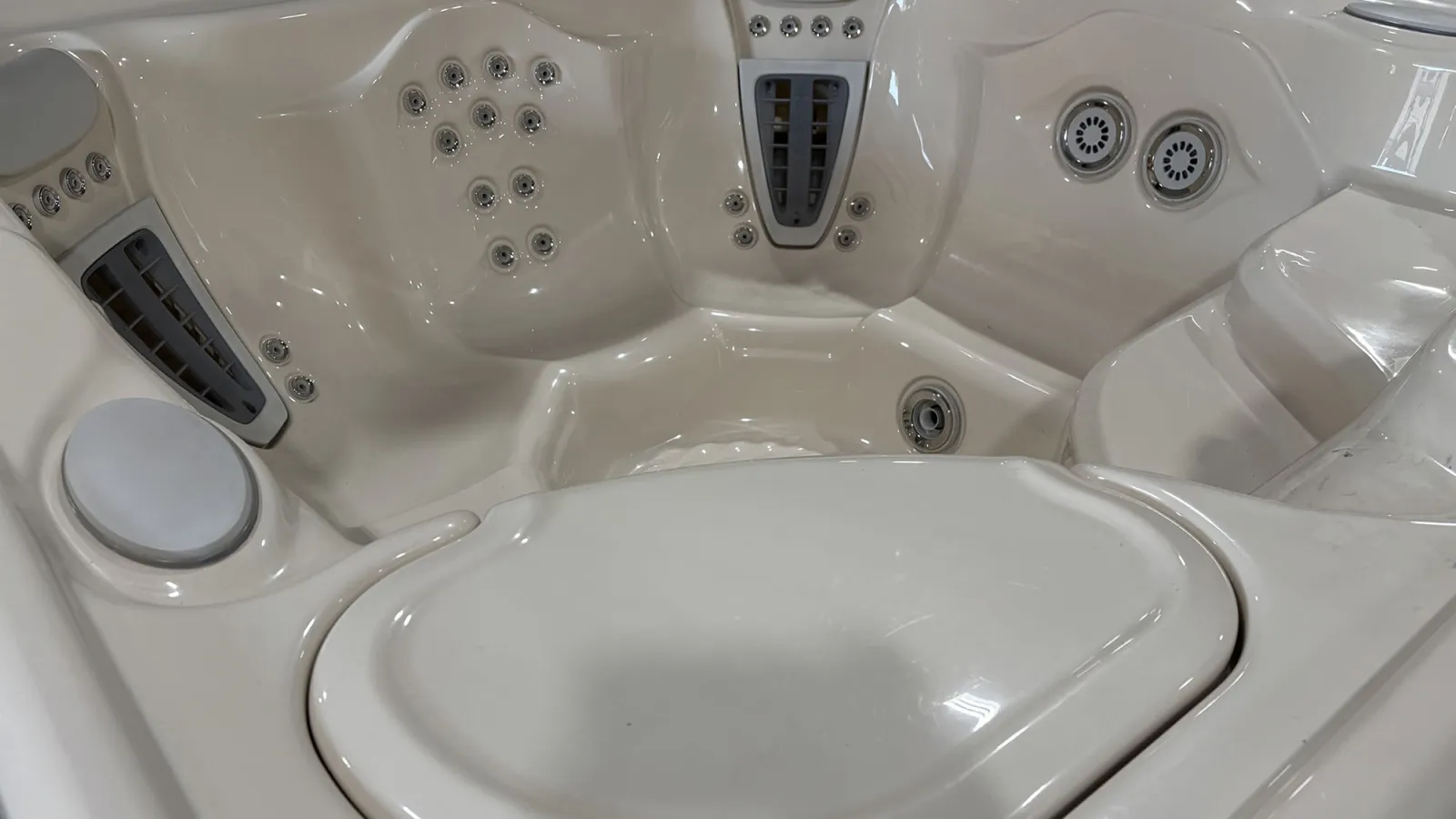 Close-up of a white luxury hot tub interior with multiple jet nozzles and ergonomic seating.