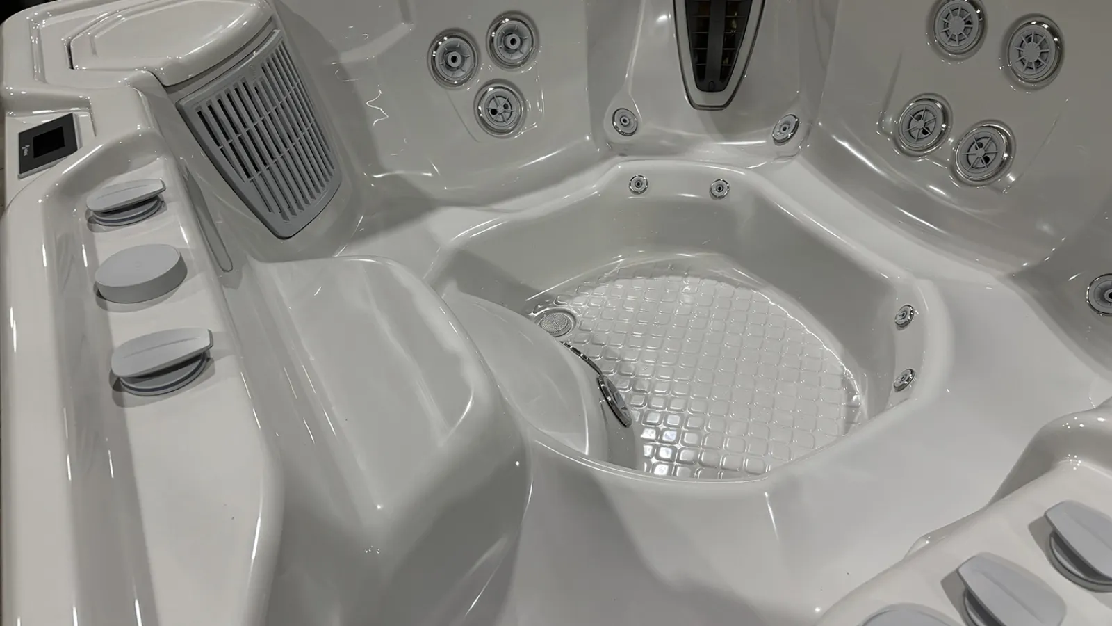 White modern hot tub interior with multiple jet nozzles and ergonomic seating design for comfort and relaxation.