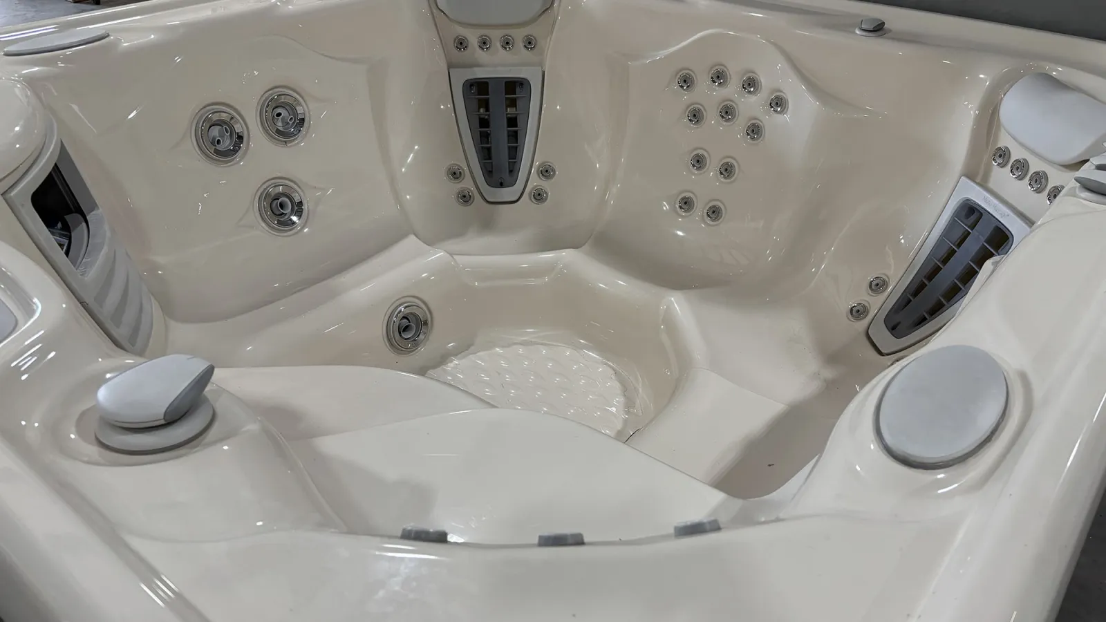 Close-up of a white jacuzzi hot tub interior with multiple jets and contoured seating.