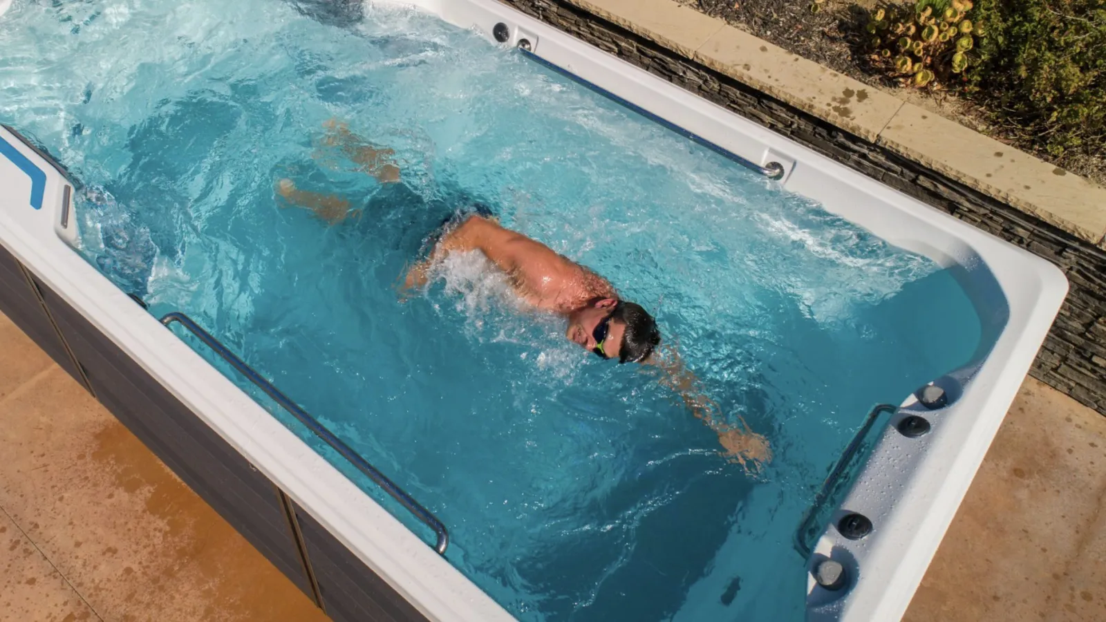 a person in a large blue swim spa