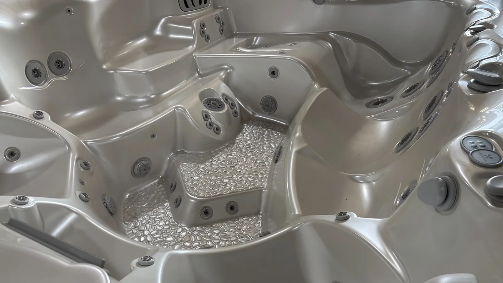 Modern silver hot tub with multiple jet nozzles and ergonomic seating for relaxation and hydrotherapy.