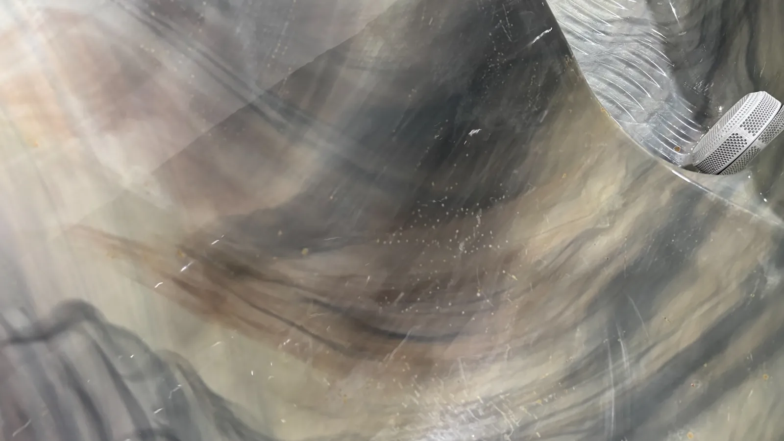 Close-up of a metallic surface with light reflections and abstract patterns showing texture and shine.