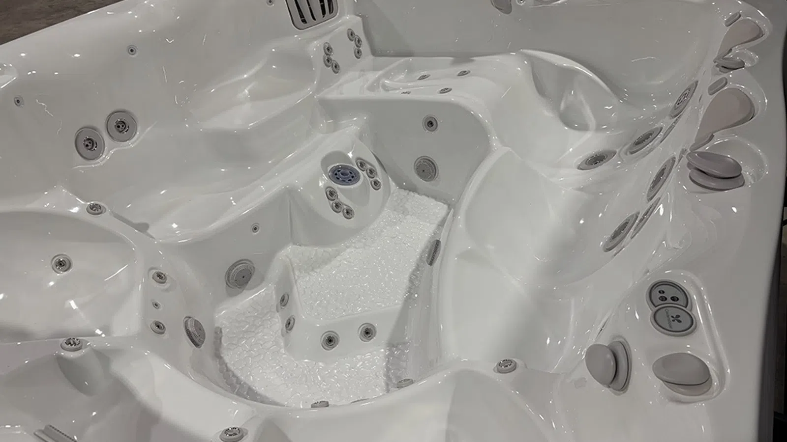 White luxury hot tub with multiple jet seats and ergonomic design for relaxation and hydrotherapy.