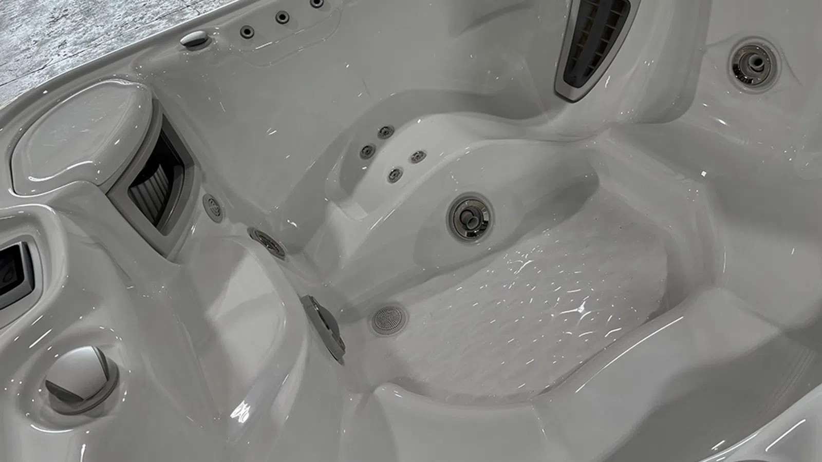 Close-up of a white multi-seat hot tub interior with built-in jets and ergonomic seating design