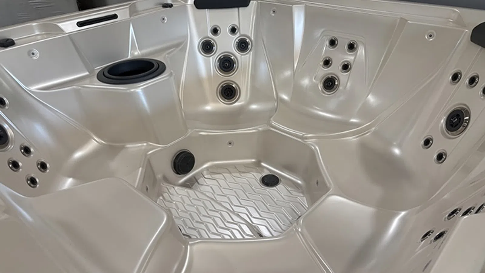 Interior view of a modern silver spa hot tub with multiple built-in jets and seating areas.