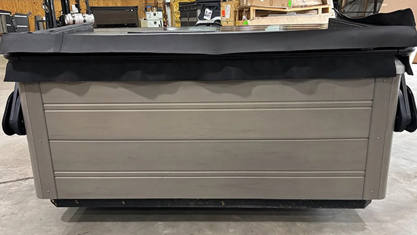Gray storage container with a black soft cover in an industrial warehouse setting on concrete floor.