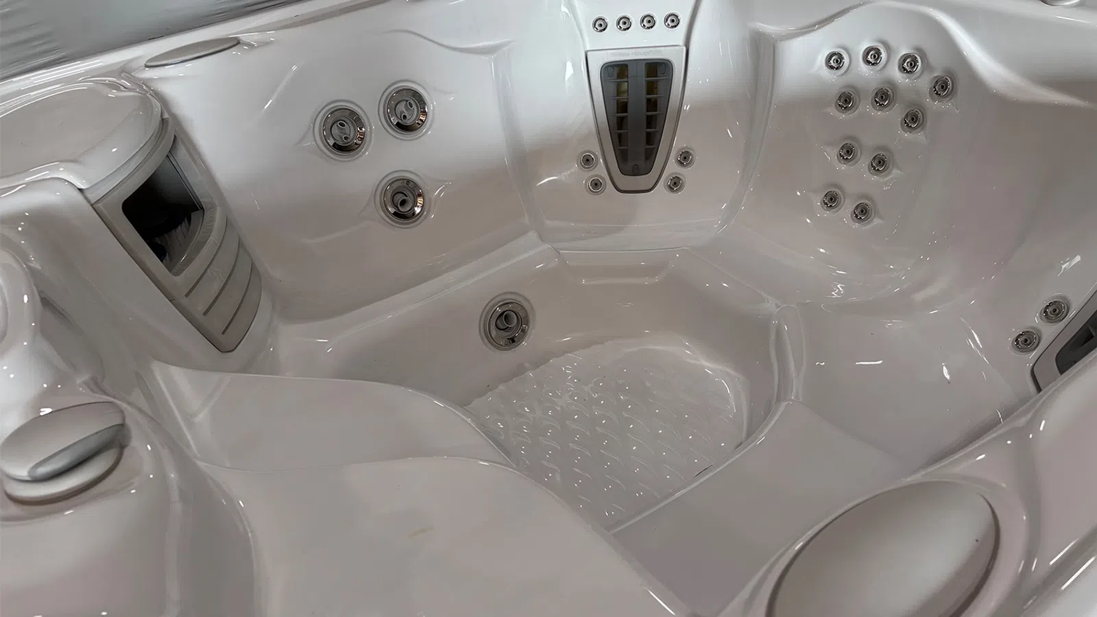 Close-up of a white modern hot tub interior with multiple jets and ergonomic seating features.