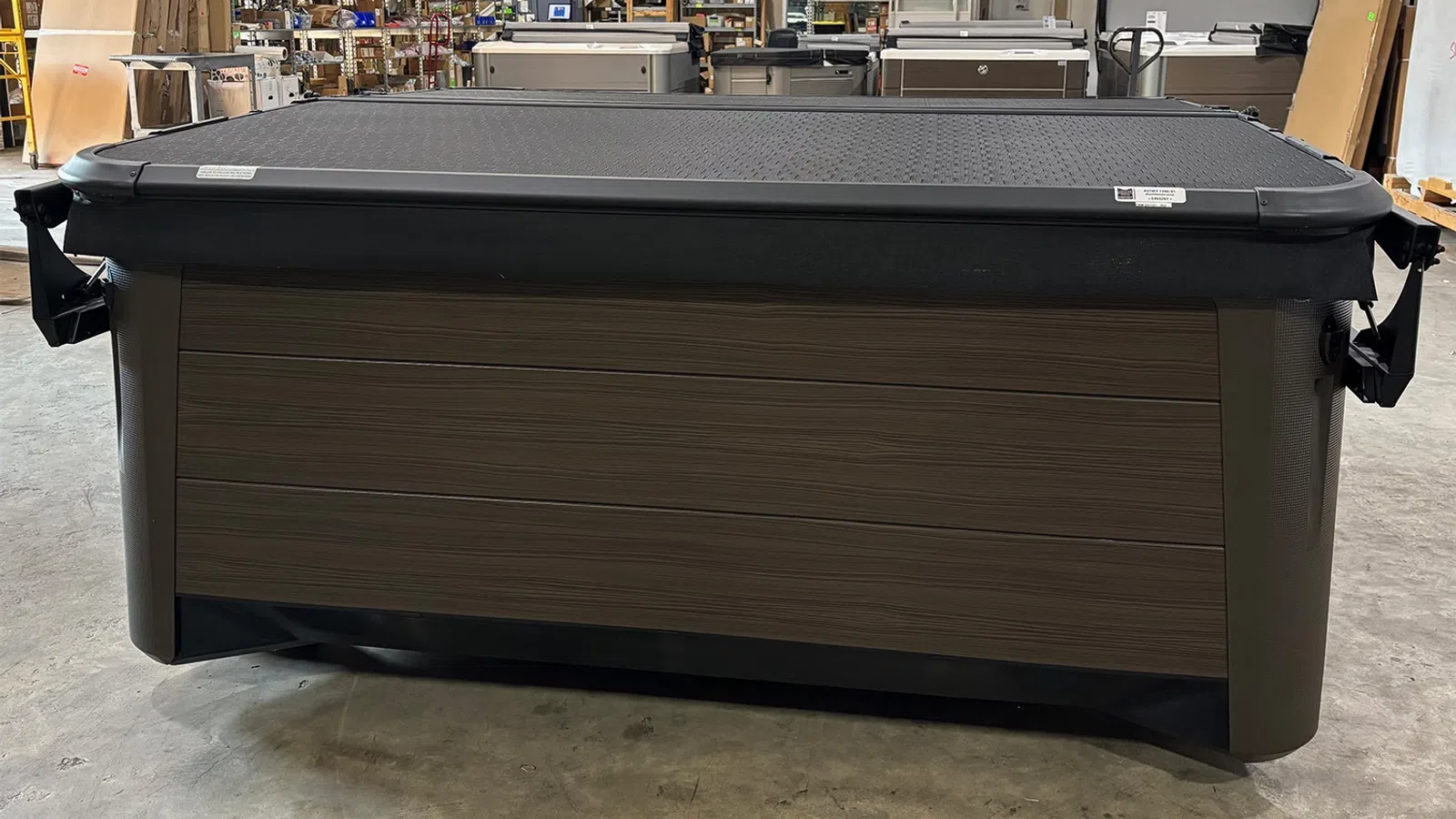Modern outdoor hot tub with textured cover in a warehouse setting