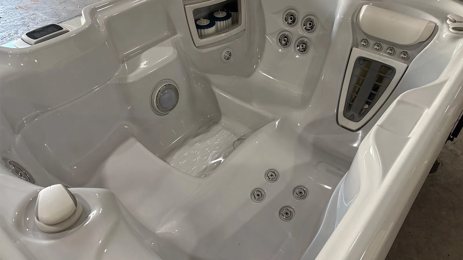 Modern white hot tub with multiple jets, built-in controls, and ergonomic seating for relaxation.