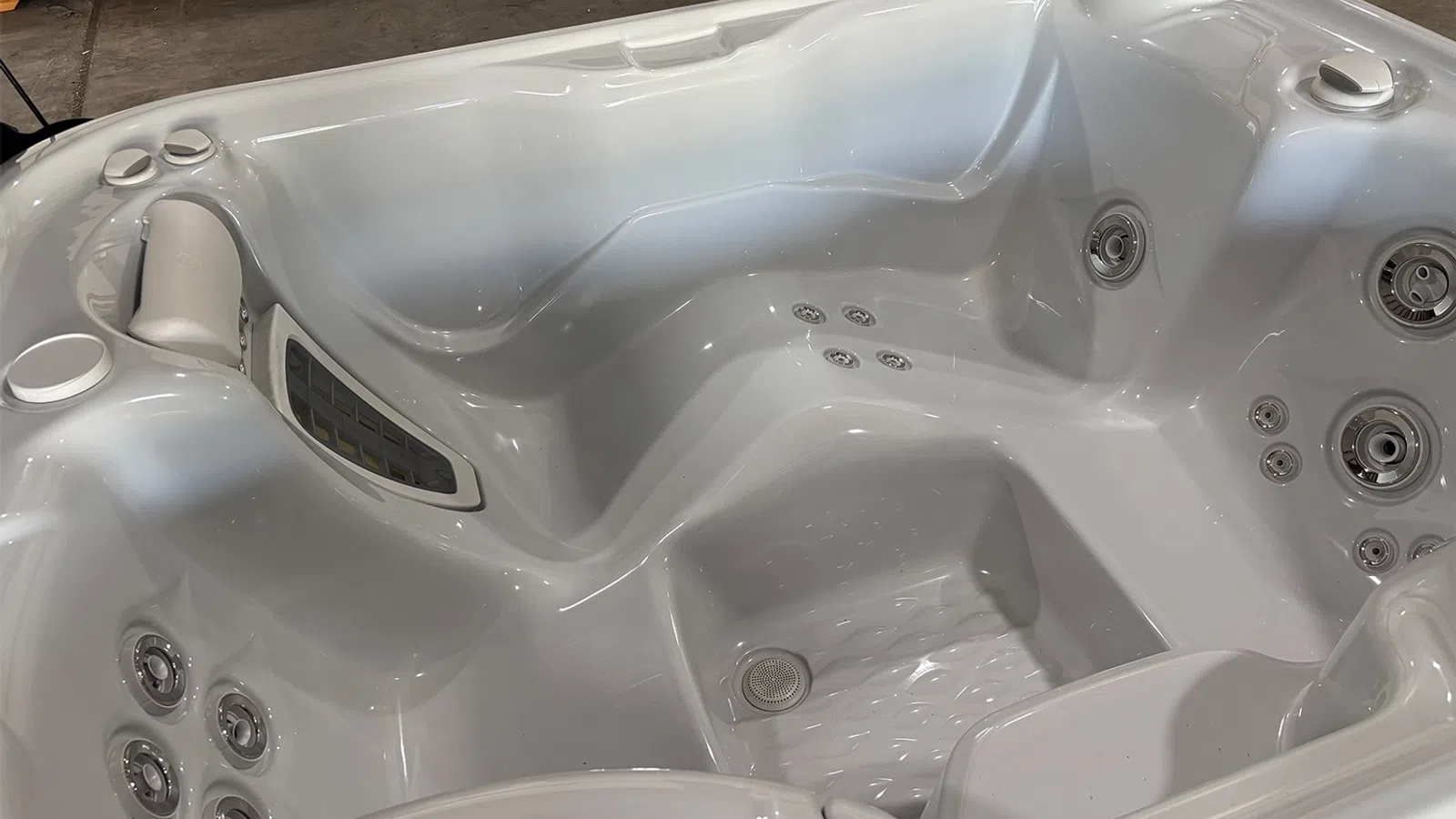 White acrylic hot tub with multiple jets and ergonomic seating for relaxing hydrotherapy experience.