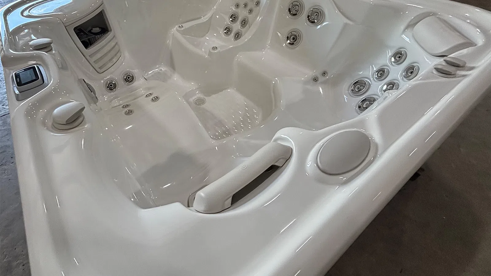 White luxury hot tub with multiple jets and ergonomic seats ready for relaxation indoors.