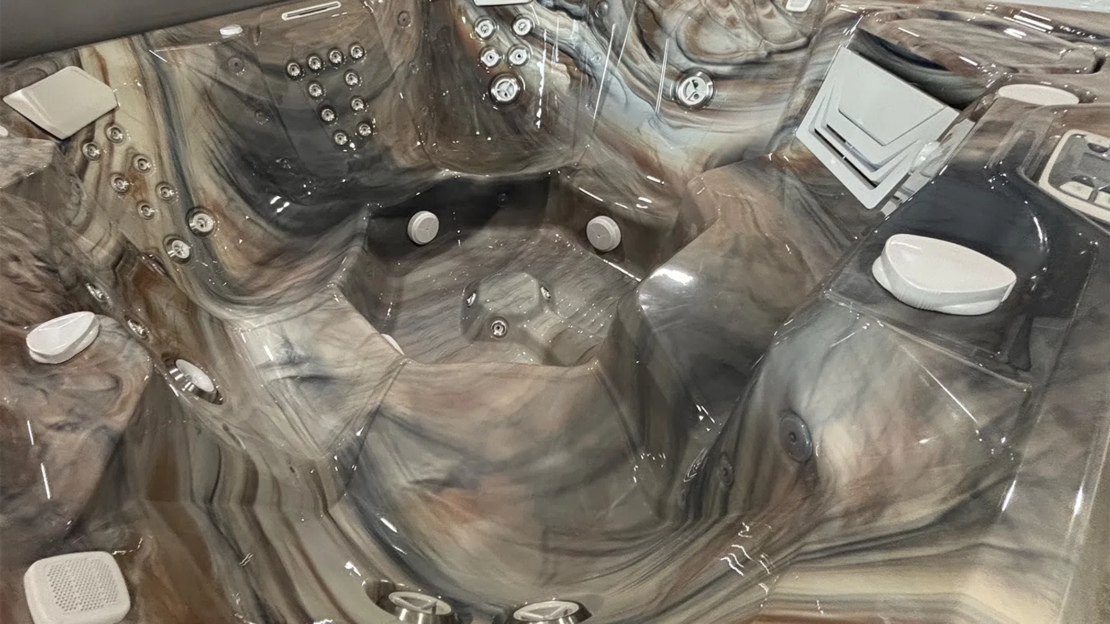 Modern marble-patterned hot tub with multiple jets, ergonomic seats, and control panel for relaxation and hydrotherapy.