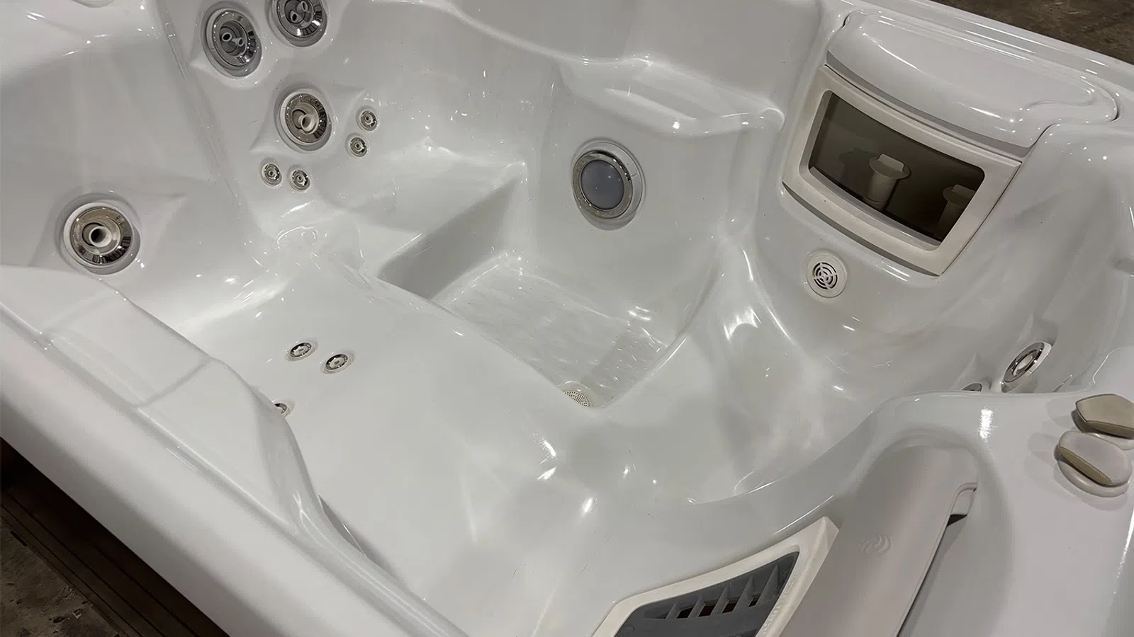 White empty spa hot tub with multiple jets and ergonomic seating designed for relaxation and hydrotherapy.
